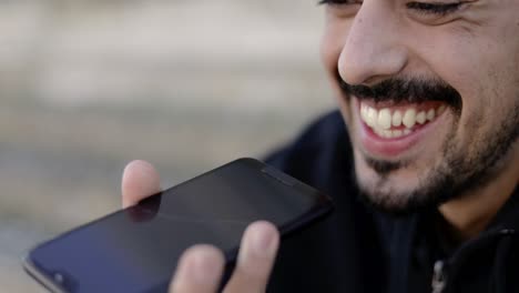 Cropped-shot-of-smiling-man-recording-voice-message